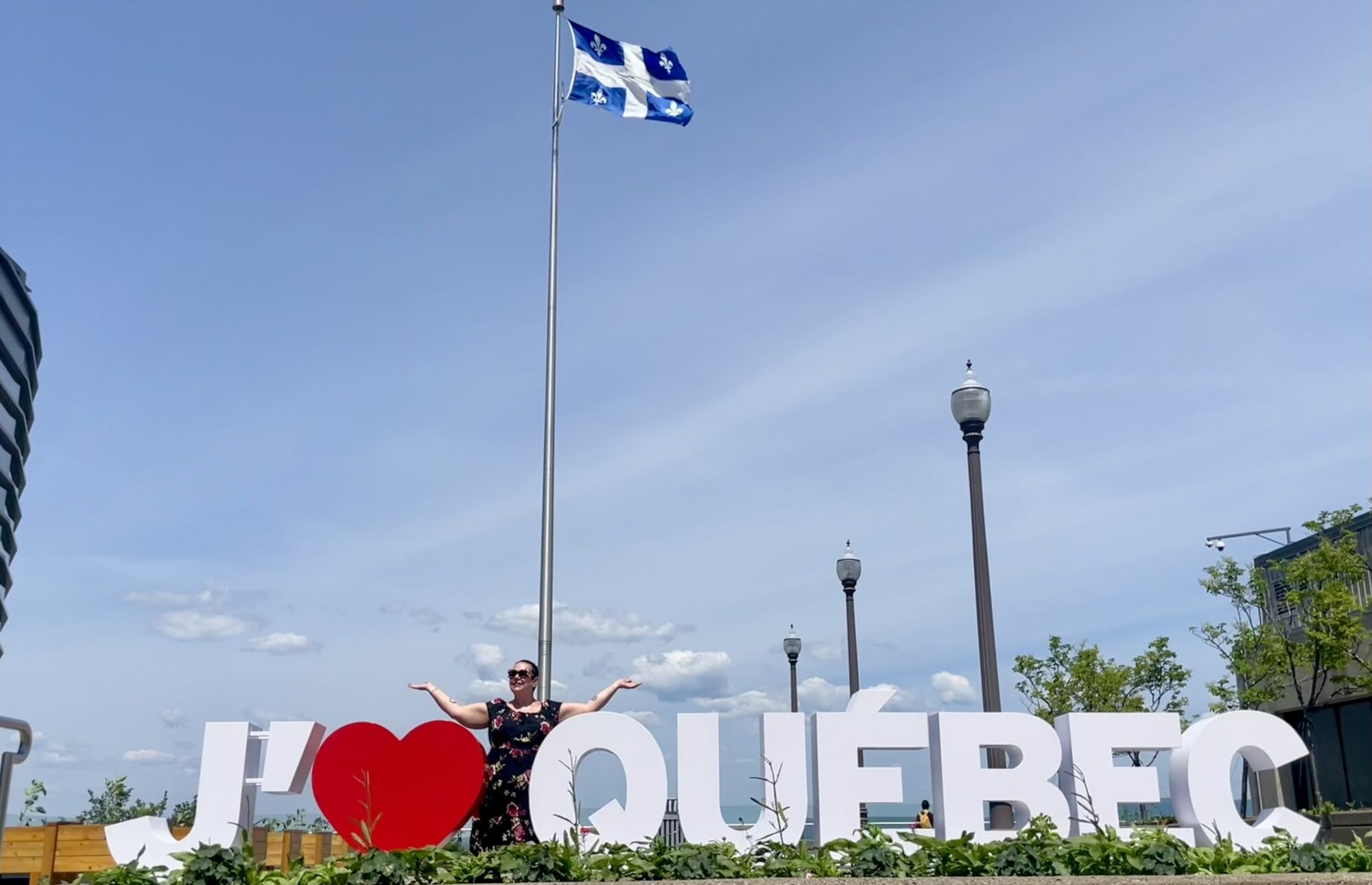 Woman standing with an I Love Quebec City and flag in Quebec City
